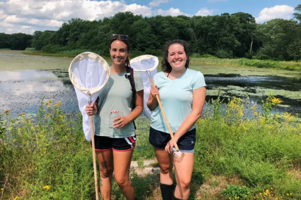 At-the-time fourth-year students Casey Johnson and Danielle Butler pose with insect nets before collecting bees for research in 2019. PHOTO CREDIT: Rhody Today