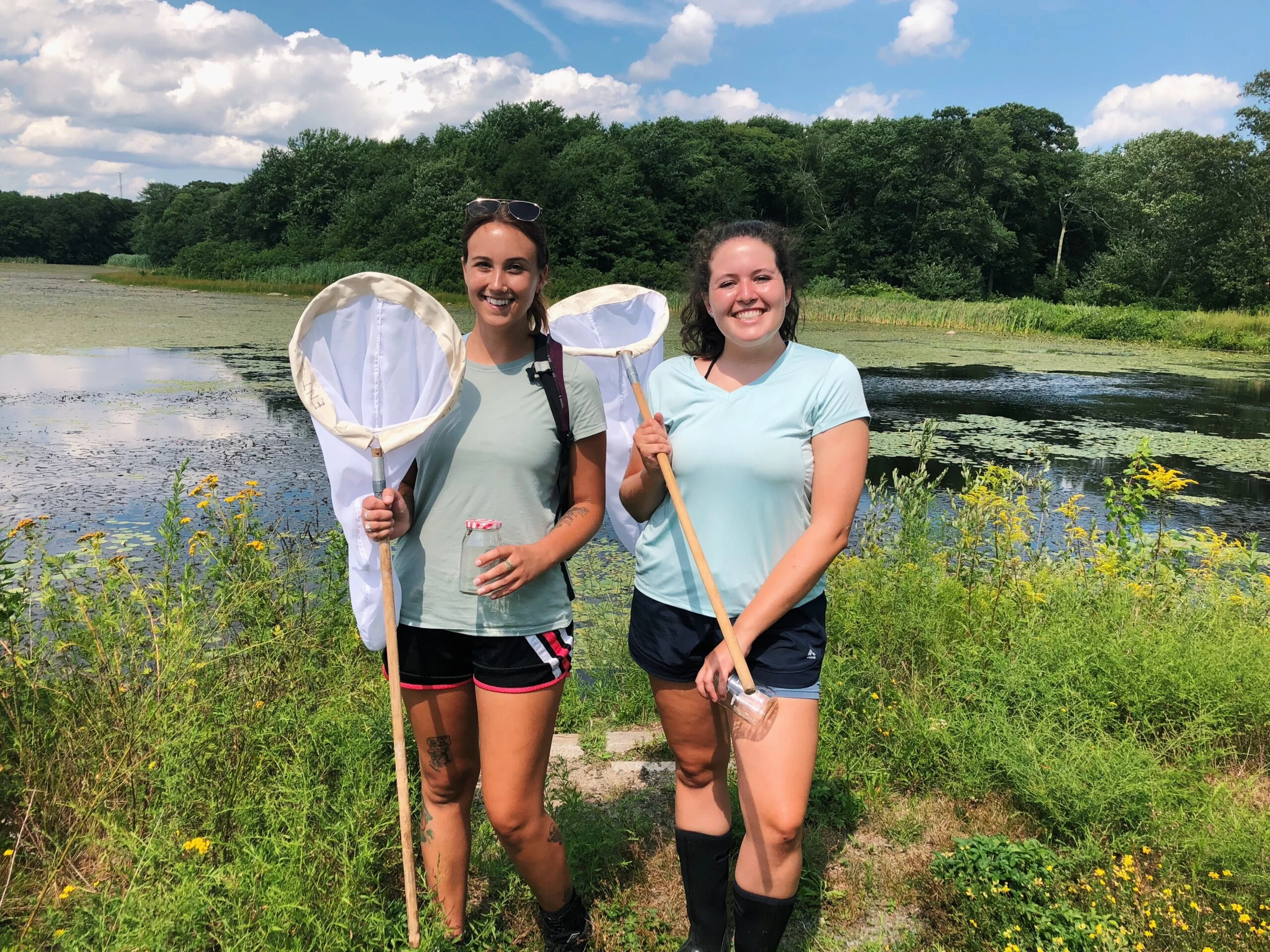 At-the-time fourth-year students Casey Johnson and Danielle Butler pose with insect nets before collecting bees for research in 2019. PHOTO CREDIT: Rhody Today