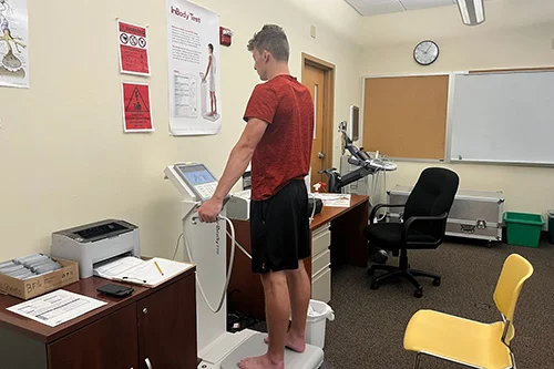 A student tests the InBody 770 machine, part of a kinesiology study. PHOTO CREDIT: URI Health and Performance Testing Lab