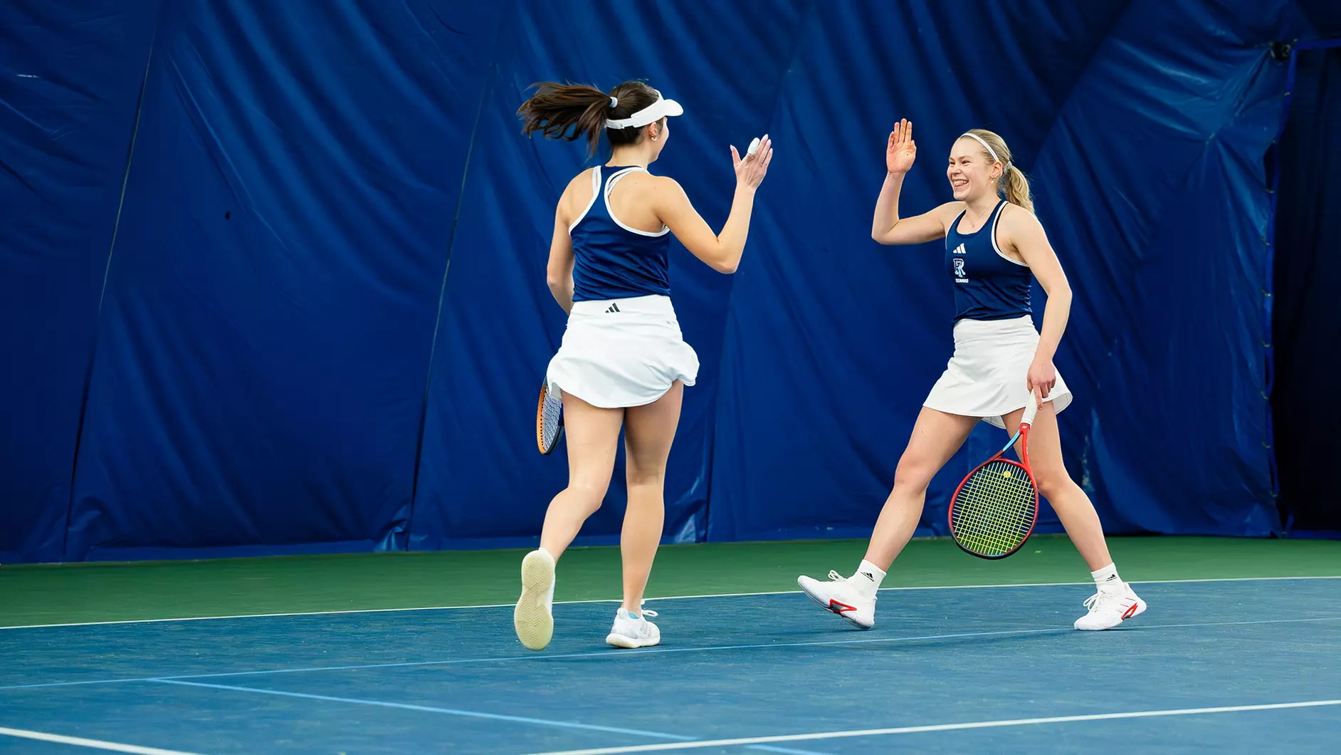 Third-year Sophie Herrman and fourth-year Klara Nelander celebrate their win against Sacred Heart on Feb. 23. PHOTO CREDIT: Michael Larkin / GoRhody.com