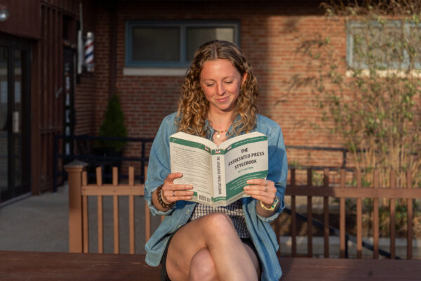 Fourth-year News Editor Abbie Chipps analyzes the AP Style book. PHOTO CREDIT: Nora Kelley | Photo Editor