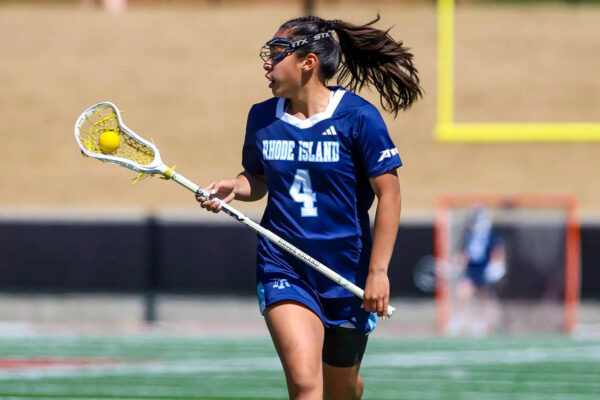 Second-year attacker Caralie Basuel cradles the ball as she runs upfield in the Rams’ win over Duquesne on Saturday. PHOTO CREDIT: Kenny Sposato/GoRhody.com
