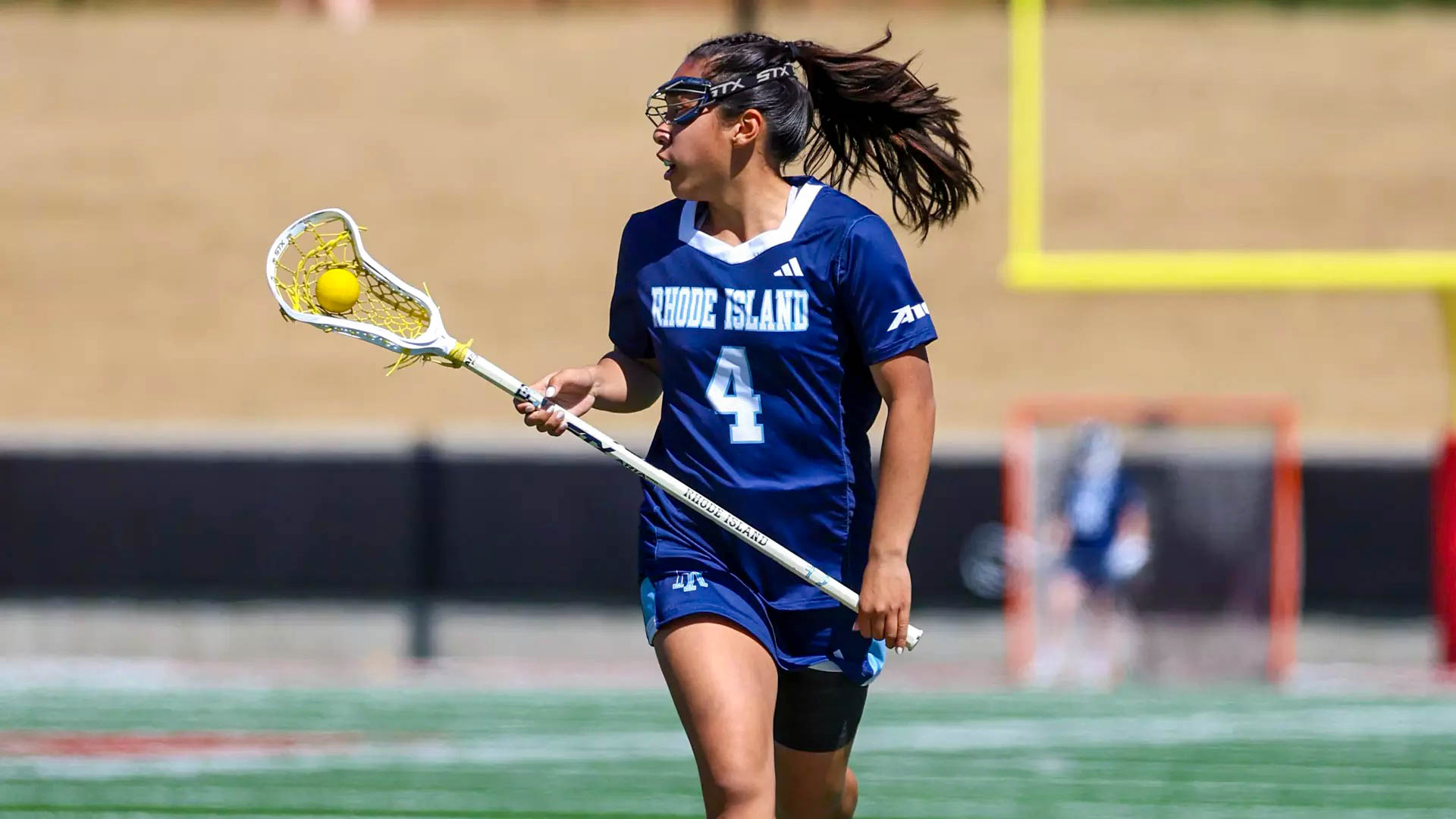 Second-year attacker Caralie Basuel cradles the ball as she runs upfield in the Rams’ win over Duquesne on Saturday. PHOTO CREDIT: Kenny Sposato/GoRhody.com