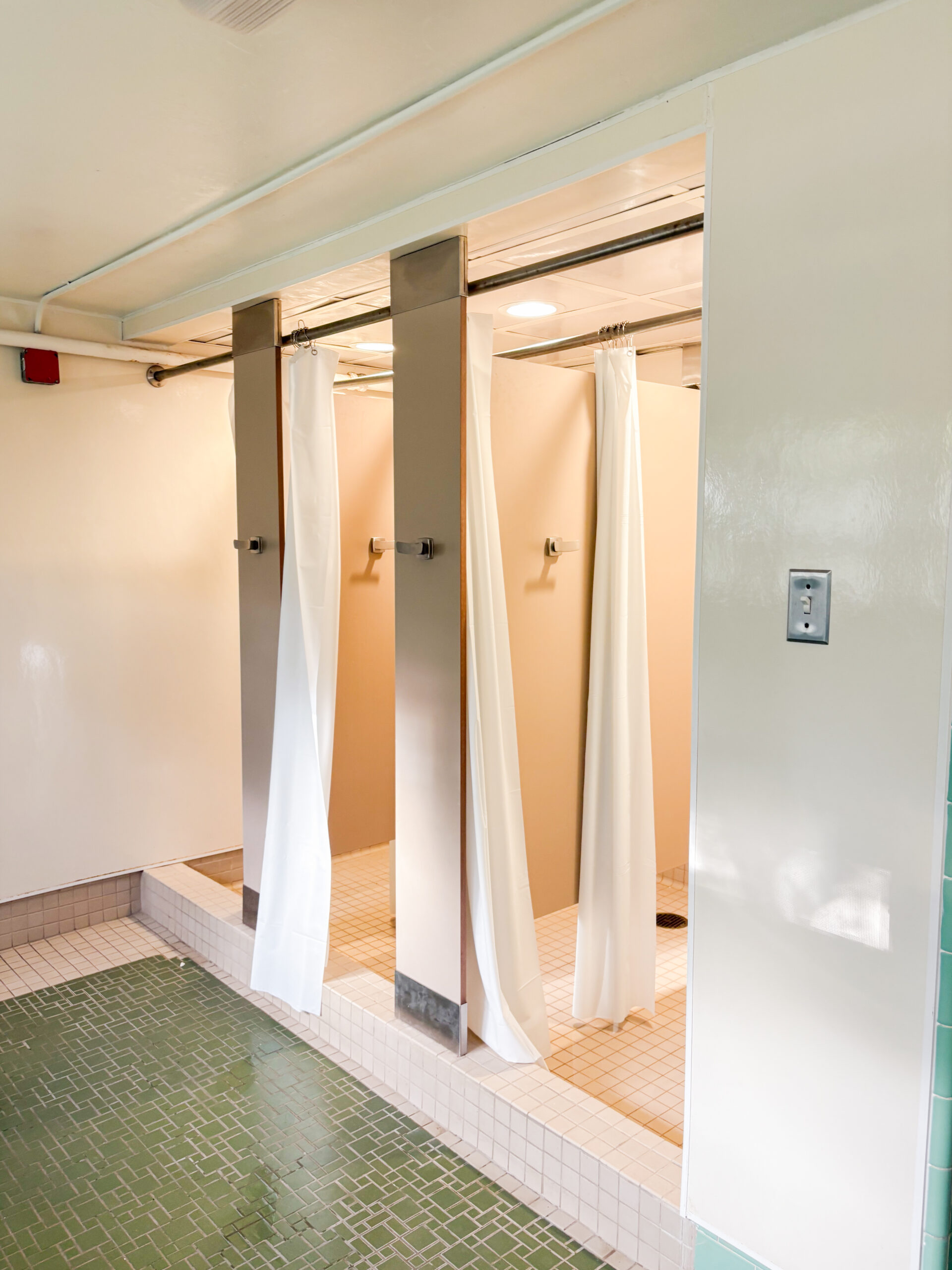 Three shower stalls in one of Adams Hall gender neutral bathrooms. PHOTO CREDIT: Skylar Connor | Staff Photographer